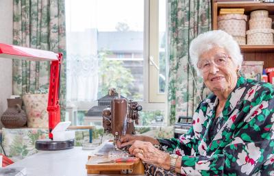 Mevrouw Staal zit achter de naaimachine