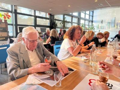 Ouderen en medewerkers van Cordaan prikken gezamenlijk een vorkje.